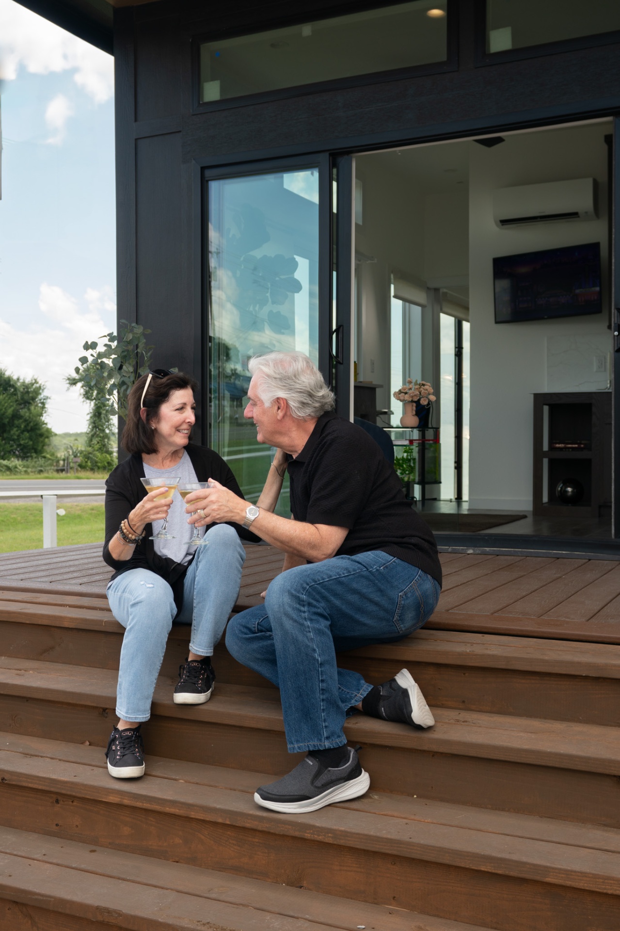 Couple on front steps with drinks