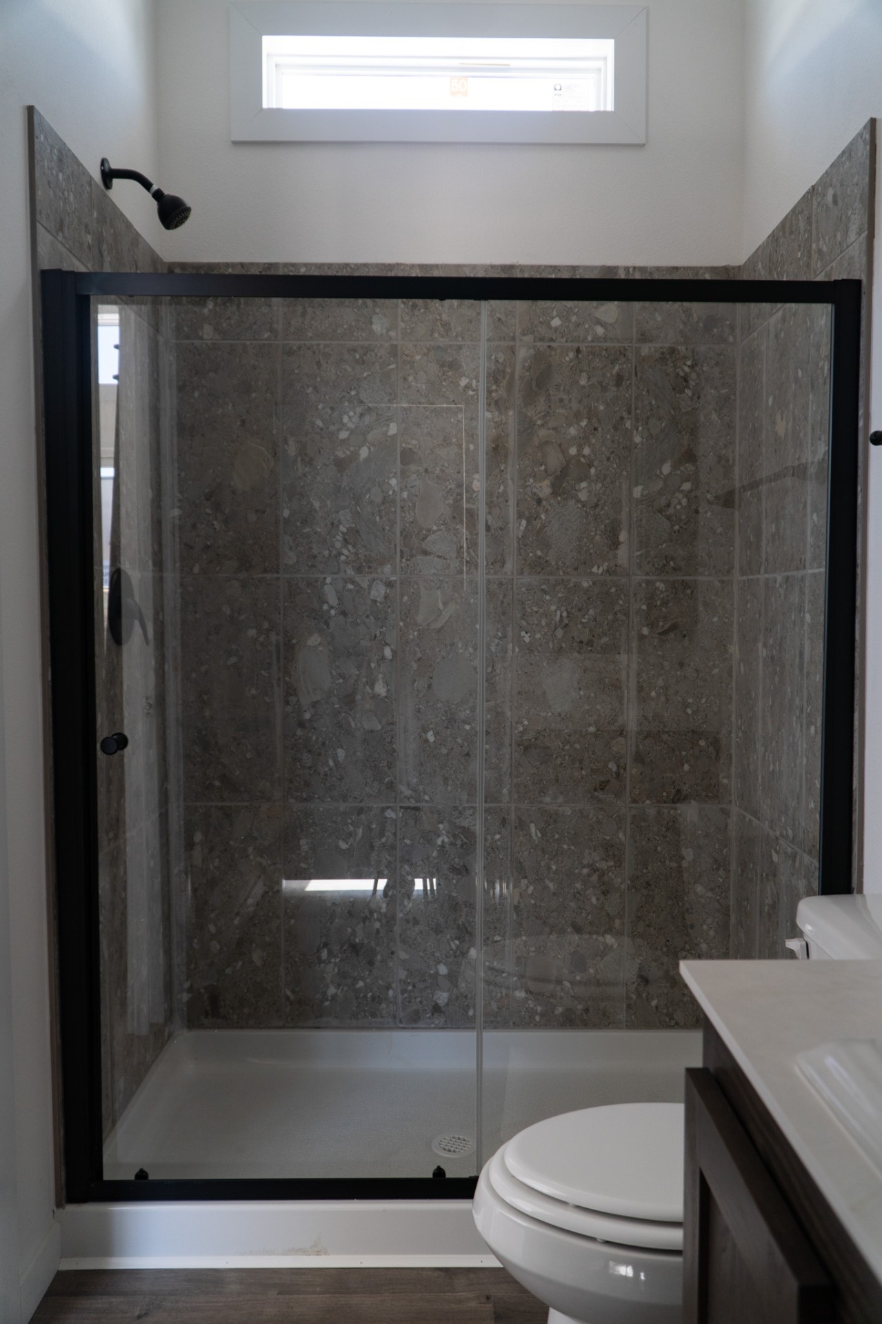 Glass shower with stone tile surround